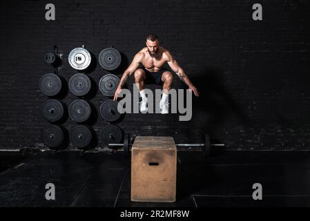 Jeune actif forte Sweaty focalisé ajustement musclé homme avec de grands muscles tenant le poids lourd kettlebell haltères barbell pour balancer entraînement crossfit dur Banque D'Images