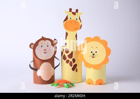 Singe jouet, girafe et lion en papier toilette hubs avec tortue de plastique sur fond blanc. Idées faites à la main pour les enfants Banque D'Images