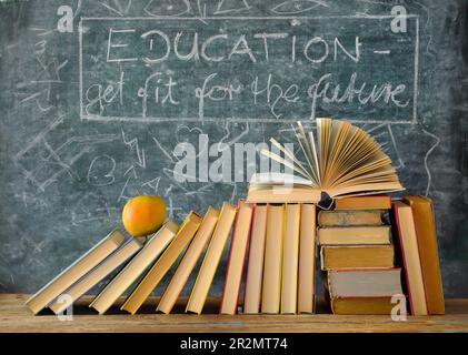 Pile de livres hardback avec slogan devant un tableau noir.Learning,Education,reading,back to School concept. Banque D'Images