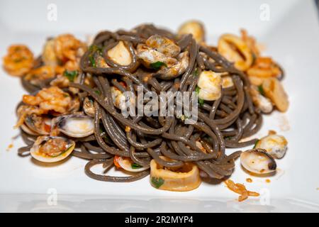 Spaghetti noirs à l'encre sépia avec fruits de mer, palourdes et coquilles. Nero di seppia Banque D'Images