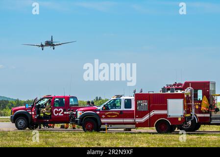 Le C-47, Placid Lassie, survolant les camions d'incendie de l'escadre 104th lors du salon international de l'aviation de Westfield, le 14th mai 2023. Banque D'Images