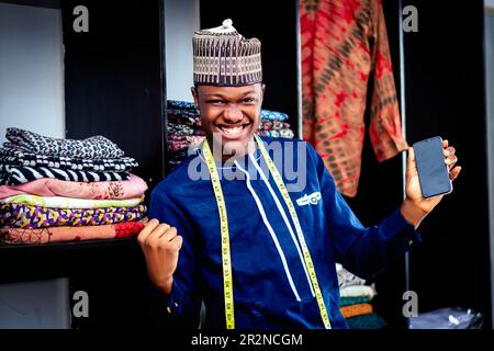Un homme africain dans une chemise africaine bleue et un ruban de mesure autour de son cou Banque D'Images