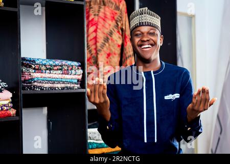 Photo d'un Africain debout devant un porte-vêtements coloré Banque D'Images