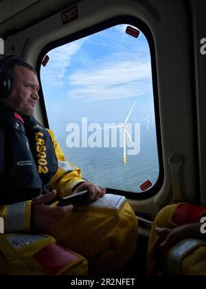 Personnel, volant au large d'un parc éolien. Banque D'Images