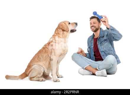 Un homme heureux jouant avec son Labrador Retriever mignon sur fond blanc Banque D'Images