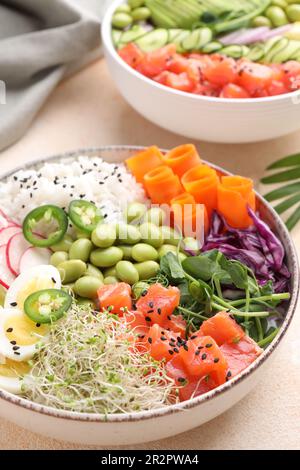 Délicieux poke bols avec des légumes, du poisson et des haricots édamames sur une table lumineuse, en gros plan Banque D'Images