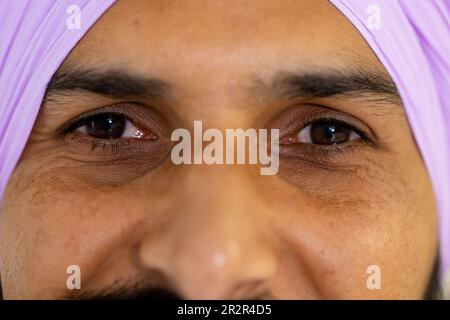 Portrait du médecin sikh heureux en turban regardant l'appareil photo et souriant Banque D'Images