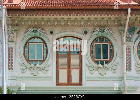 Extérieur de la maison d'achats chinois ou Peranakan très orné avec volets en bois marron, fenêtres rococo et colonnes en plâtre très décoratives Banque D'Images