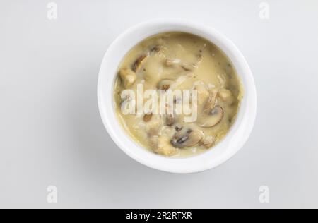 Sauce aux champignons dans un bol blanc isolé, vue du dessus image studio de sauce crémeuse aux champignons Banque D'Images