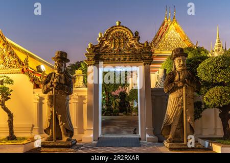 Riesige Wächterfigungen Farang Guard am Eingang zum buddhistischen Tempel Wat Pho in der Abenddämmerung, Bangkok, Thaïlande, Asie | Giant Farang Gu Banque D'Images