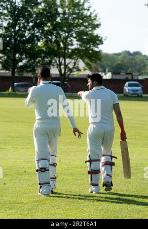 Club cricket, Warwick, Angleterre, Royaume-Uni. Joueurs qui marchent sur le terrain. Banque D'Images