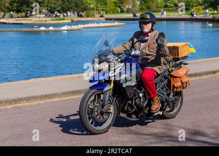 Poole, Dorset Royaume-Uni. 21 mai 2023 Bournemouth et Poole Distinguished Gentlemen’s Ride est un événement annuel, l’un des nombreux dans le monde, qui vise à recueillir des fonds et à sensibiliser la population à la santé des hommes. Dans le cadre de leur balade, des centaines de motos, beaucoup vintage, traversent Poole Park sur leur chemin vers Bournemouth avec beaucoup de leurs coureurs habillés de manière appropriée, dans des cravates de style rétro, des moustaches et des tweeds par une belle journée ensoleillée. Vieil homme âgé vêtu d'une veste et d'un noeud papillon chevauchant Triumph Tiger moto avec panier pique-nique sur le dos ondulant crédit : Carolyn Jenkins/Alamy Live News Banque D'Images