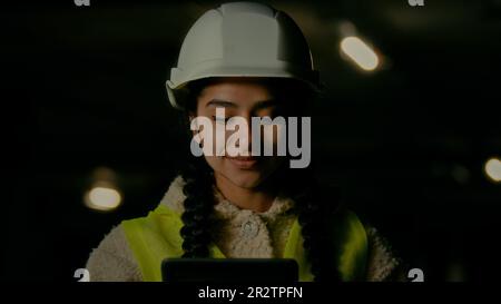 Une femme inspecteur superviseur architecte développeur Angry agacé femme dans hardhat inspectant les mauvais travaux d'ingénierie sur le stationnement souterrain utilisation électronique Banque D'Images
