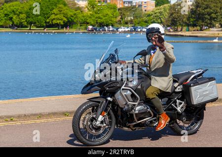 Poole, Dorset Royaume-Uni. 21 mai 2023 Bournemouth et Poole Distinguished Gentlemen’s Ride est un événement annuel, l’un des nombreux dans le monde, qui vise à recueillir des fonds et à sensibiliser la population à la santé des hommes. Dans le cadre de leur balade, des centaines de motos, beaucoup vintage, traversent Poole Park sur leur chemin vers Bournemouth avec beaucoup de leurs coureurs habillés de manière appropriée, dans des cravates de style rétro, des moustaches et des tweeds par une belle journée ensoleillée. Vieilli homme habillé en costume veste gilet gilet de costume et noeud papillon chevauchant BMW R 1250 R1250 ondulation crédit : Carolyn Jenkins/Alamy Live News Banque D'Images