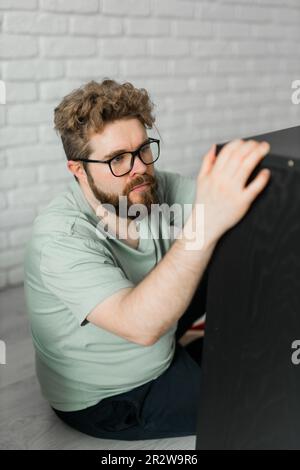 Portrait de l'homme assemblant des meubles. Faites-le vous-même assemblage de meubles à la maison Banque D'Images
