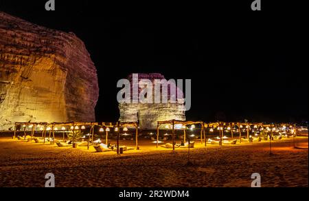 Salon extérieur éclairé en face du monolithe d'érosion des rochers d'éléphant, debout dans le désert de nuit, Al Ula, Arabie Saoudite Banque D'Images