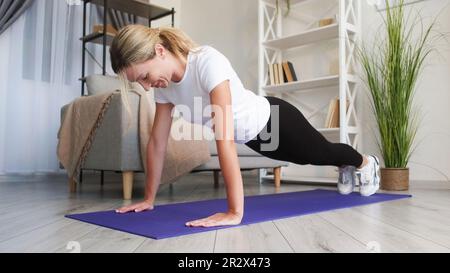 Entraînement à domicile femme de forme physique intérieure faisant planche Banque D'Images