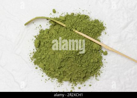 Cuillère de mesure en poudre de matcha vert et bambou pour préparer du thé vert matcha. Pose à plat. Arrière-plan blanc Banque D'Images