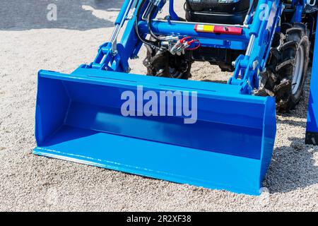 Chargeur frontal hydraulique bleu de construction et gros plan de machines agricoles. Banque D'Images