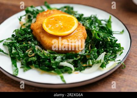 Assiette de Schnitzel végétalien sur chou de savoie sauté avec une sauce à l'orange Chili. Banque D'Images