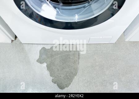 Image à angle élevé d'un lave-linge avec fuite d'eau dans le tuyau de vidange Banque D'Images