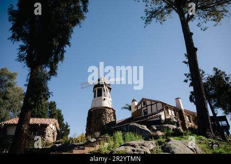 Moulin avec ancien château de roche. toit en carreaux rouges et guirlande de lumières. Moulin à vent moderne. Campagne par une belle journée d'été Banque D'Images