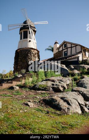 Moulin avec ancien château de roche. toit en carreaux rouges et guirlande de lumières. Moulin à vent moderne. Campagne par une belle journée d'été Banque D'Images