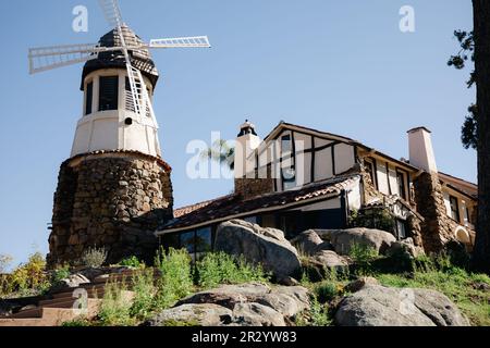 Moulin avec ancien château de roche. toit en carreaux rouges et guirlande de lumières. Moulin à vent moderne. Campagne par une belle journée d'été Banque D'Images