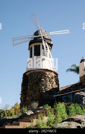 Moulin avec ancien château de roche. toit en carreaux rouges et guirlande de lumières. Moulin à vent moderne. Campagne par une belle journée d'été Banque D'Images