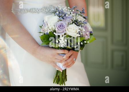 Gros plan du bouquet de mariage avec des roses blanches, crème et violettes, hors foyer avec espace de copie. Banque D'Images