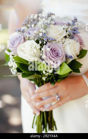 Gros plan du bouquet de mariage avec des roses blanches, crème et violettes, hors foyer avec espace de copie. Banque D'Images