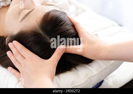 Femme recevant un massage du cuir chevelu et la main du praticien Banque D'Images