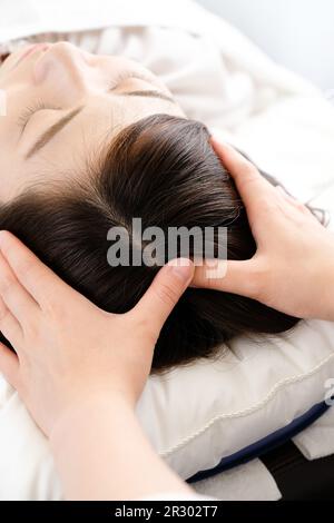 Femme recevant un massage du cuir chevelu et la main du praticien Banque D'Images