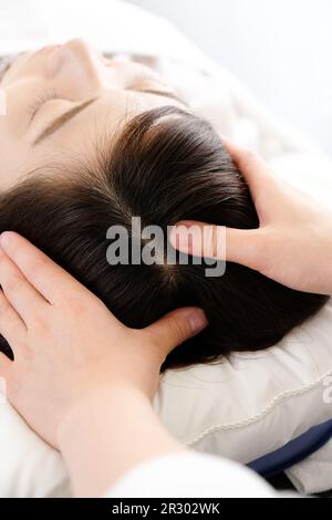 Femme recevant un massage du cuir chevelu et la main du praticien Banque D'Images