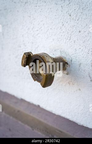 Raccord de tuyau d'eau extérieur sur un mur en béton blanc. Banque D'Images