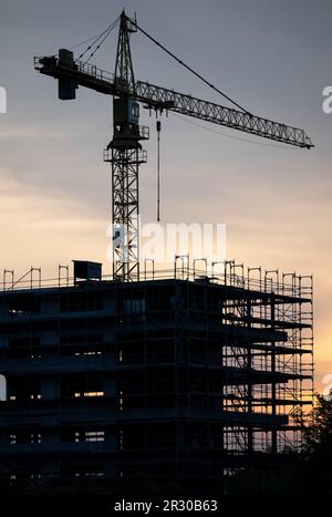 22 mai 2023, Saxe, Schkeuditz: Des grues se tiennent derrière la coque d'un immeuble de bureaux sur un chantier de construction à l'aéroport de Leipzig/Halle à Schkeuditz. Au début de la nouvelle semaine, selon le DWD, il restera chaud en Allemagne après le week-end estival, mais il devrait devenir de plus en plus humide et orageux. Lundi commencera dans la moitié est du pays avec des cieux ensoleillés à nuageux et, à part quelques orages sur les montagnes, sec. Dans l'ouest de l'Allemagne, elle sera également en partie claire au début, mais au cours de la journée, de lourds nuages de printemps se formeront. Photo: Hendrik Banque D'Images