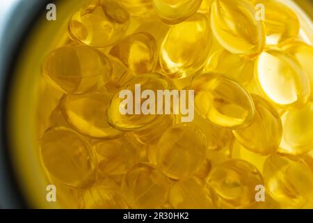 beaucoup de capsules de gélatine jaune sur fond clair. vitamines omega, gros plan, macro. Banque D'Images