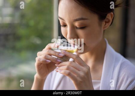 Élégante jeune femme chinoise qui boit du thé dans le salon de thé Banque D'Images