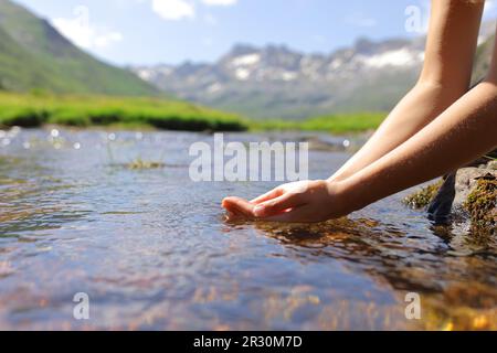 Gros plan d'une femme mains de l'eau de la rivière de montagne Banque D'Images