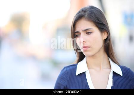 Une triste femme se plaignant de regarder vers le bas en marchant dans la rue Banque D'Images