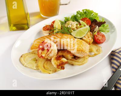 Filet de poisson poêlé au carb sur les légumes grillés - saumon rôti et crevettes sur une assiette isolée sur fond blanc Banque D'Images