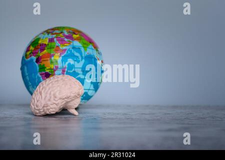 Cerveau humain et globe terrestre sur table avec espace de copie. Concept de la Journée mondiale de la santé mentale Banque D'Images