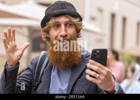 Oh mon Dieu Wow. Heureux heureux heureux heureux gagnant jeune adulte homme utiliser smartphone dactylographie navigation célébrer gagner bonne nouvelle de message. Un homme barbu de REDHEAD avec un téléphone mobile marchant dans la rue urbaine à l'extérieur Banque D'Images