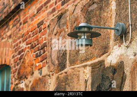 Lampe électrique extérieure fixée à une façade de bâtiment ancien à Halmstad, en Suède. Mise au point sélective. Banque D'Images