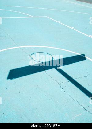 Ombre du panier de basket-ball et lignes blanches sur la surface bleue du terrain Banque D'Images