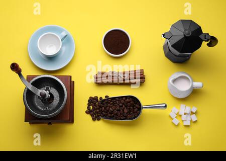 Composition de pose à plat avec moulin manuel vintage et cafetière geyser sur fond jaune Banque D'Images