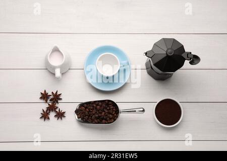 Composition Flat Lay avec machine à café geyser et grains torréfiés sur fond de bois blanc Banque D'Images