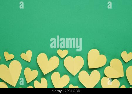 Coeurs en papier sur fond vert, couché à plat. Espace pour le texte Banque D'Images