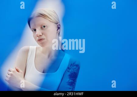 Portrait minimal de fille éthérée avec albinisme posant en couleur bleue, espace de copie Banque D'Images