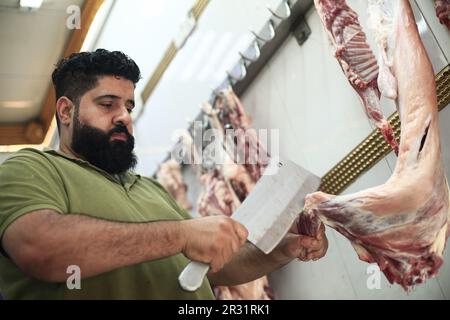 Bagdad, Irak. 22nd mai 2023. Un boucher prépare une rencontre dans son magasin de Bagdad, dans le contexte d'une augmentation des cas de fièvre hémorragique de Crimée-Congo dans le pays. Le ministère iraquien de la Santé a signalé que les cas confirmés de fièvre hémorragique de Crimée-Congo (FCMH) sont passés à 119, dont 18 décès dans tout le pays. Credit: Ameer Al-Mohammadawi/dpa/Alamy Live News Banque D'Images